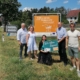 Fünf Personen präsentieren gemeinsam die neue Gebietstafel „Willkommen an der Weinstraße Weinviertel" im Rahmen des Projekts Regionsbewusstsein Weinviertel
